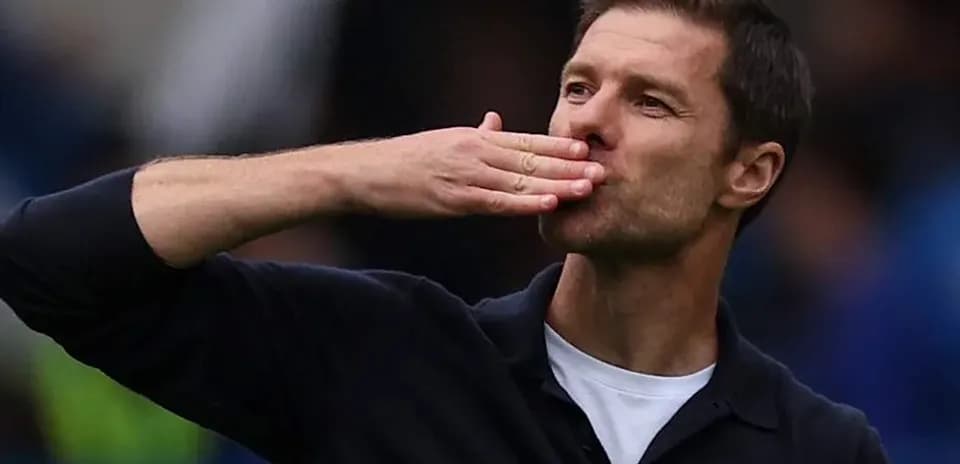 Entrenador saludando a la afición con un beso