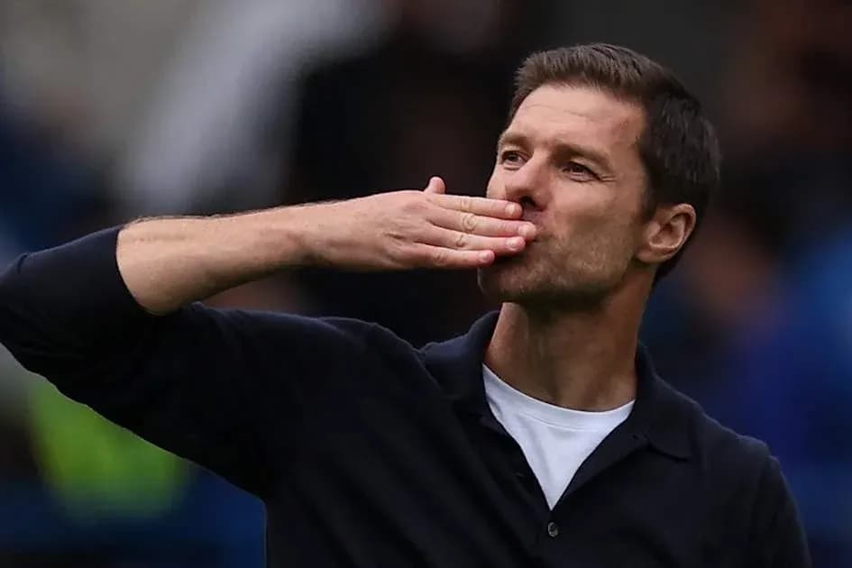 Entrenador saludando a la afición con un beso