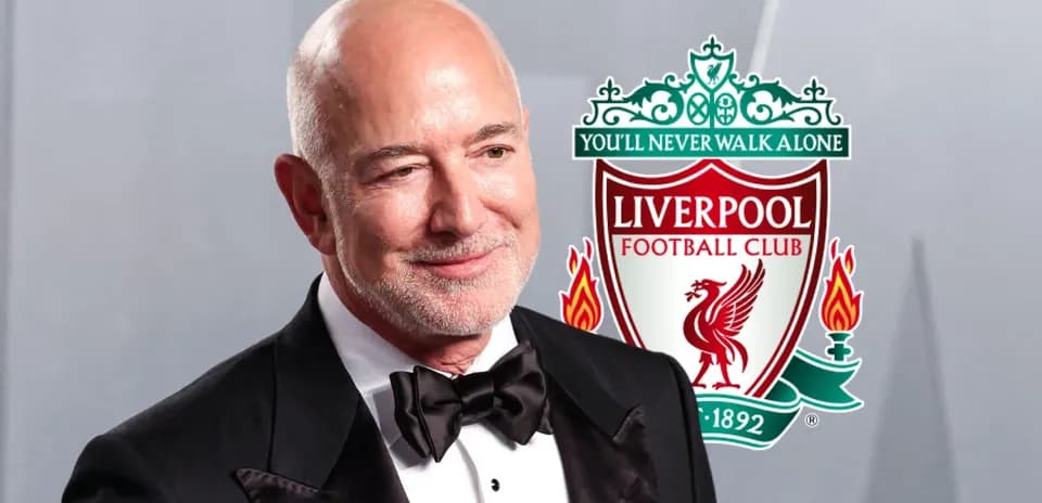 Hombre en traje con logo de Liverpool FC de fondo