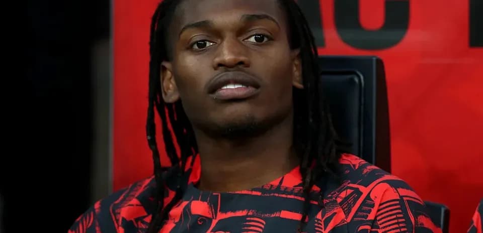 Jugador sentado en el banquillo con camiseta del AC Milan