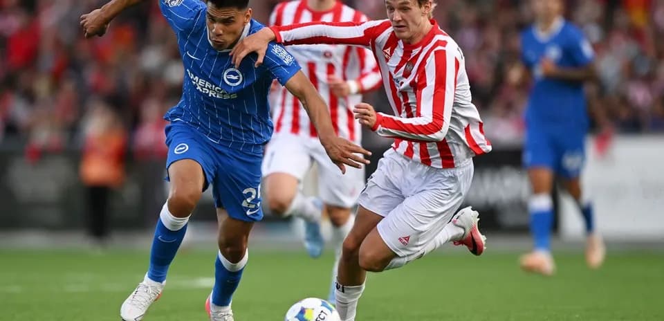 Jugador en camiseta azul luchando por el balón
