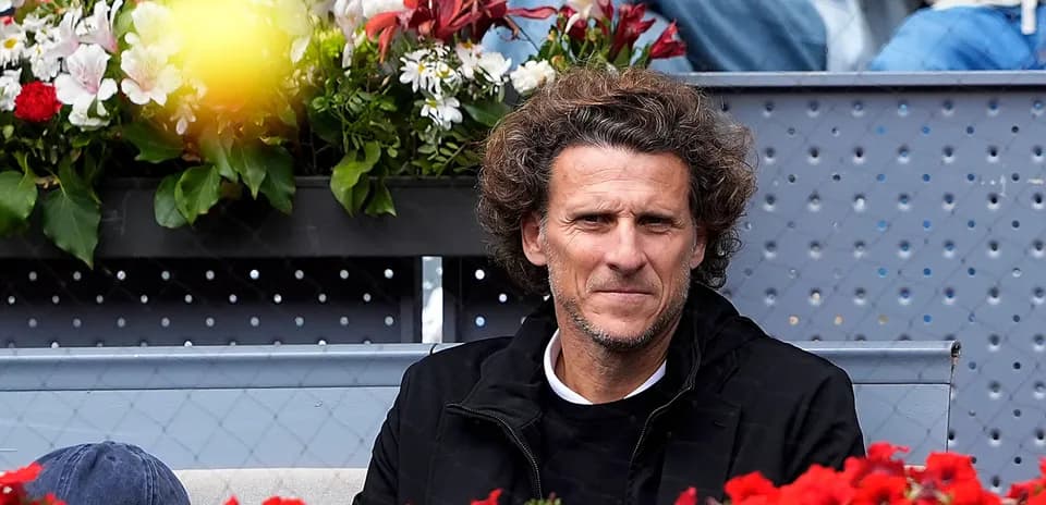 Hombre sentado en gradas con flores de fondo
