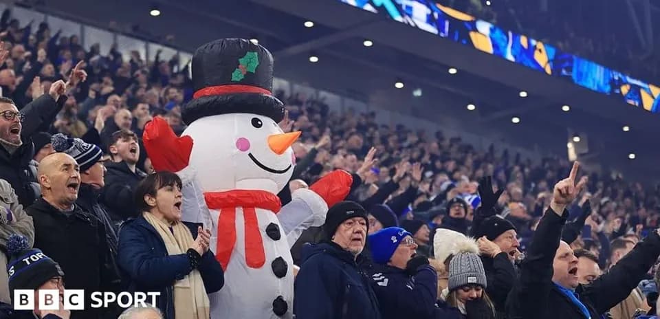 Espectadores animando con un muñeco de nieve gigante