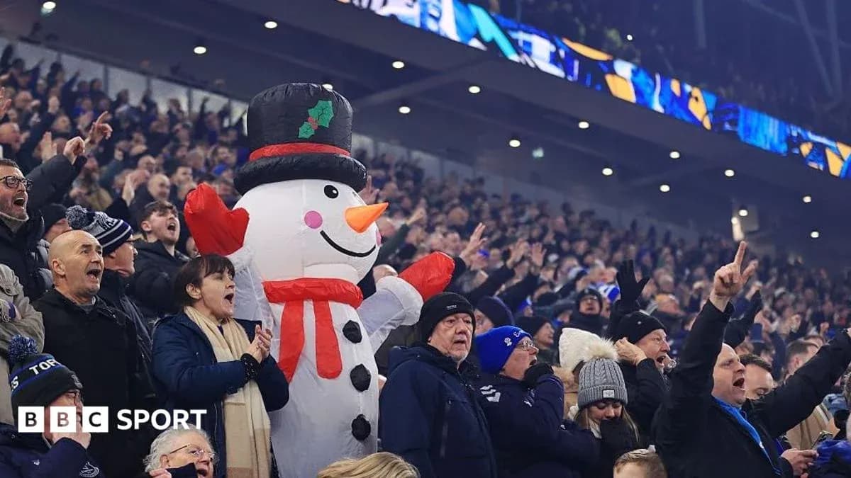 Espectadores animando con un muñeco de nieve gigante