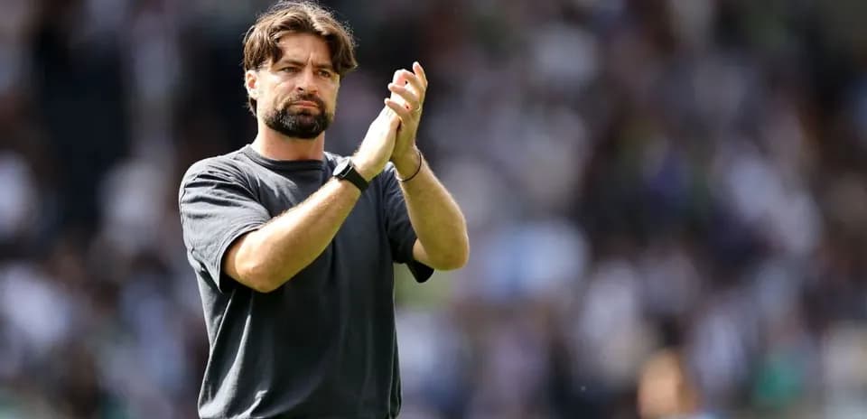 Entrenador aplaudiendo en el estadio durante partido