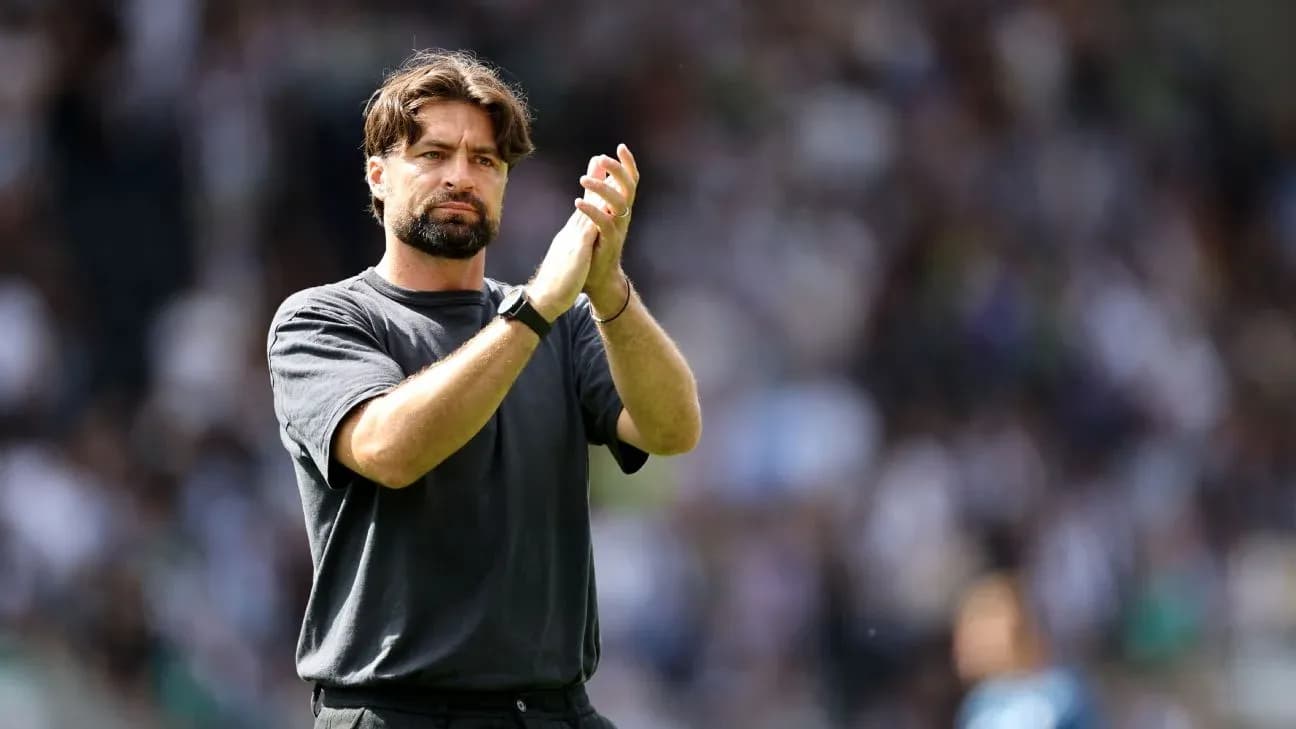 Entrenador aplaudiendo en el estadio durante partido