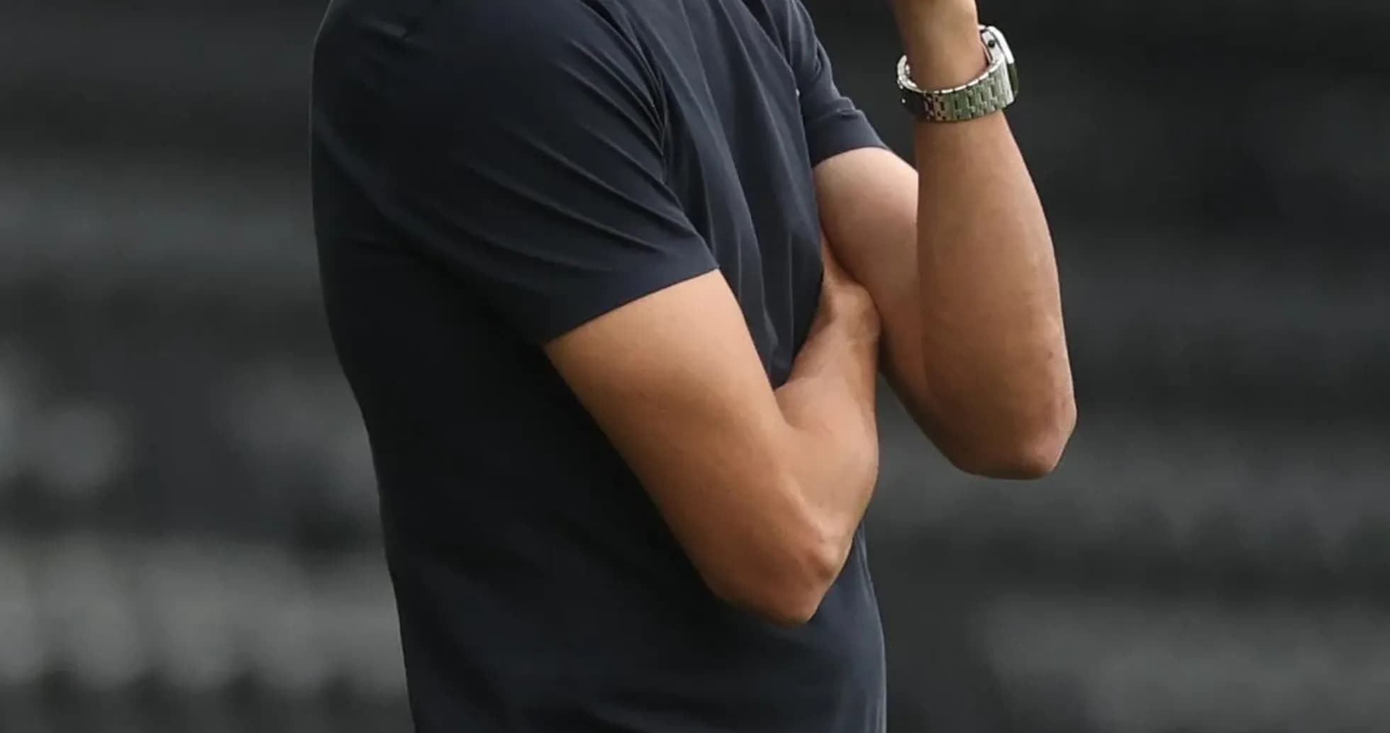 Entrenador observando el partido con los brazos cruzados