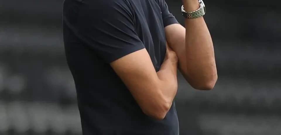 Entrenador observando el partido con los brazos cruzados