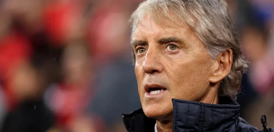 Entrenador hablando durante un partido de fútbol