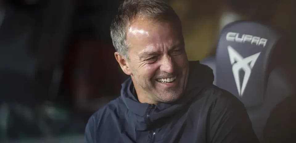 Entrenador sonriendo en el banquillo del estadio