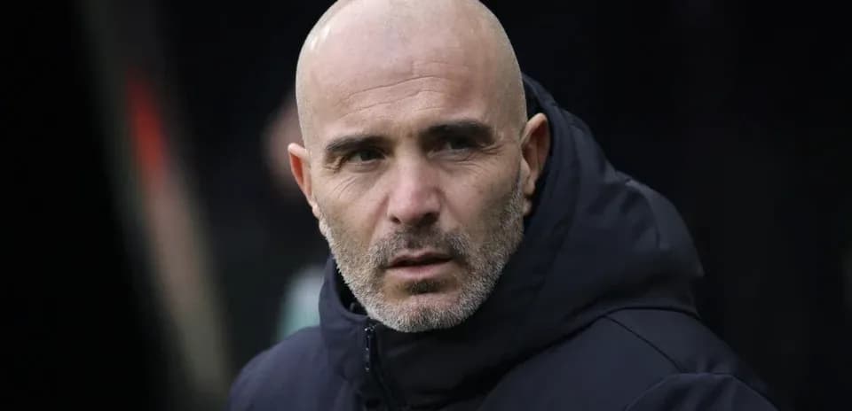 Entrenador observando desde el banquillo del estadio