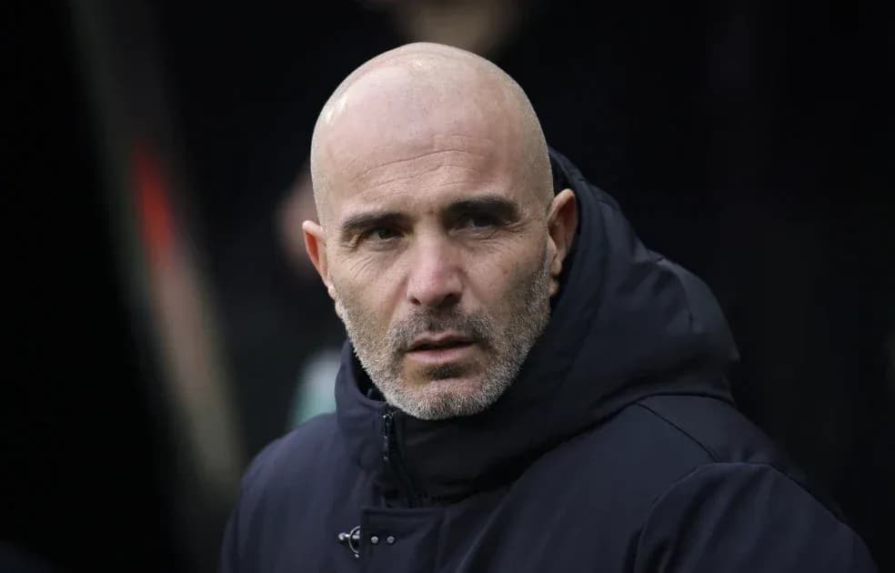 Entrenador observando desde el banquillo del estadio