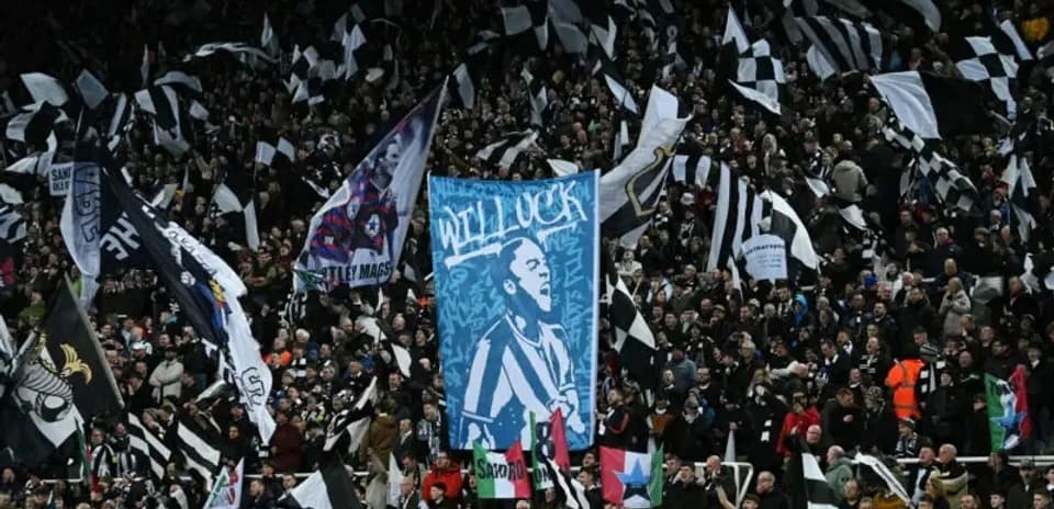 Aficionados con banderas en un estadio de fútbol