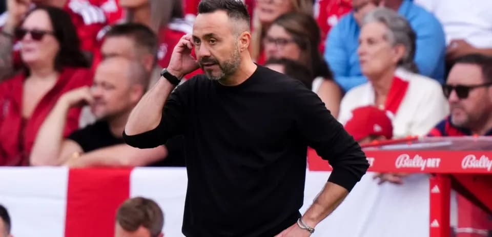 Entrenador hablando por teléfono en la línea de banda