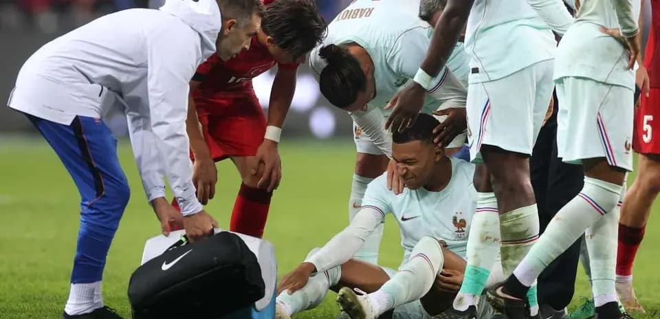 Jugadores rodeando a un compañero lesionado en el campo
