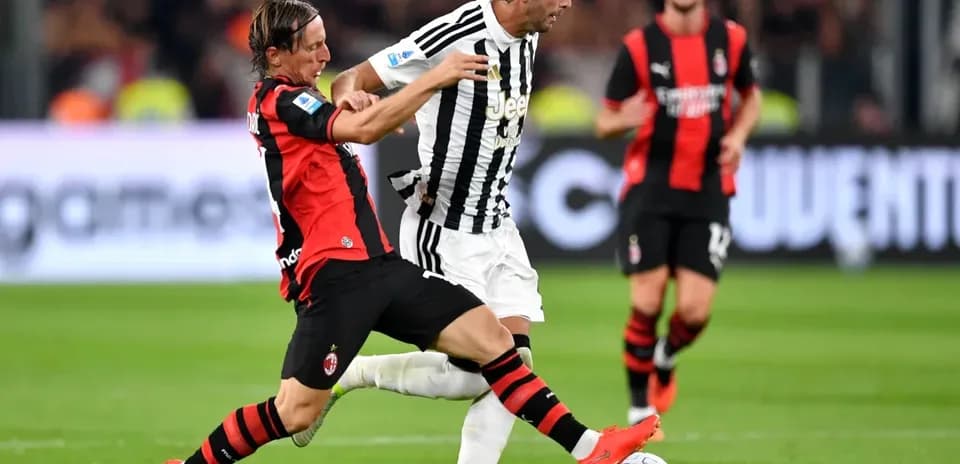Jugador de AC Milan interceptando a jugador de Juventus