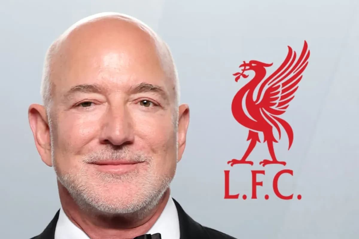 Hombre sonriente con logo de Liverpool detrás