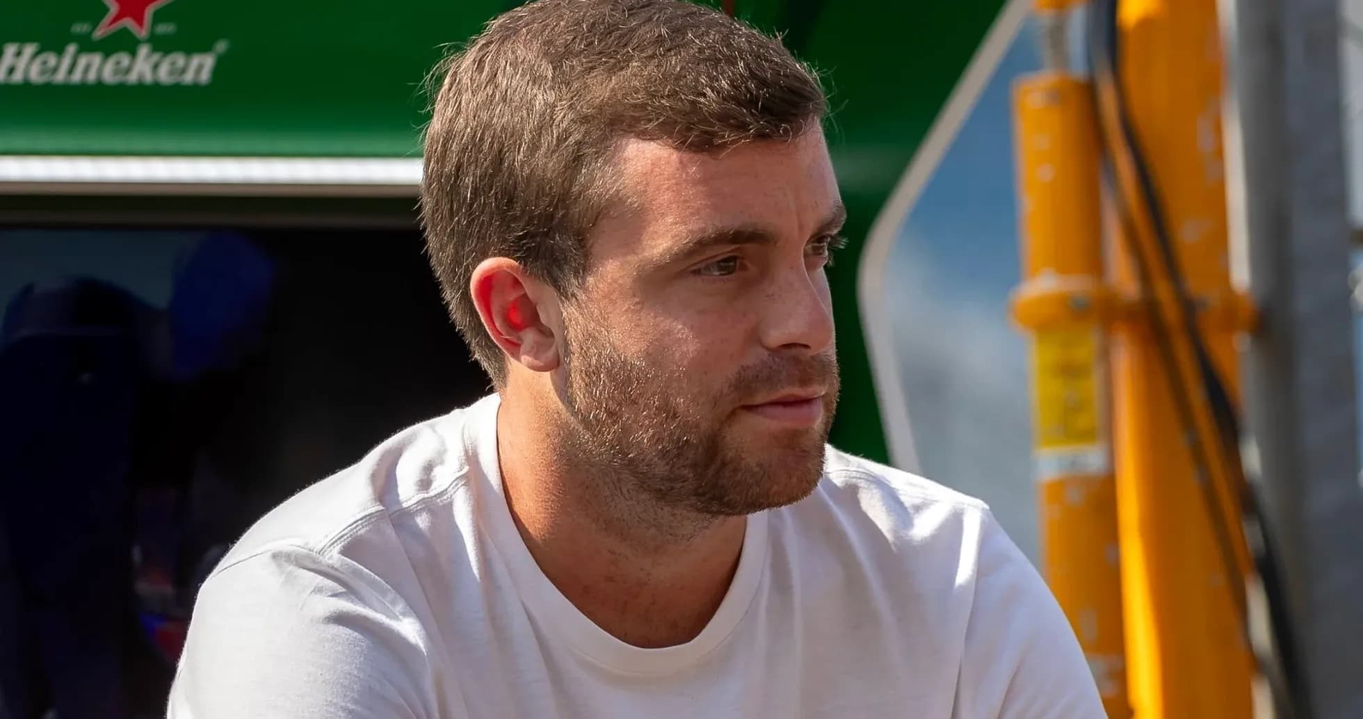 Hombre sentado con camiseta blanca en el paddock