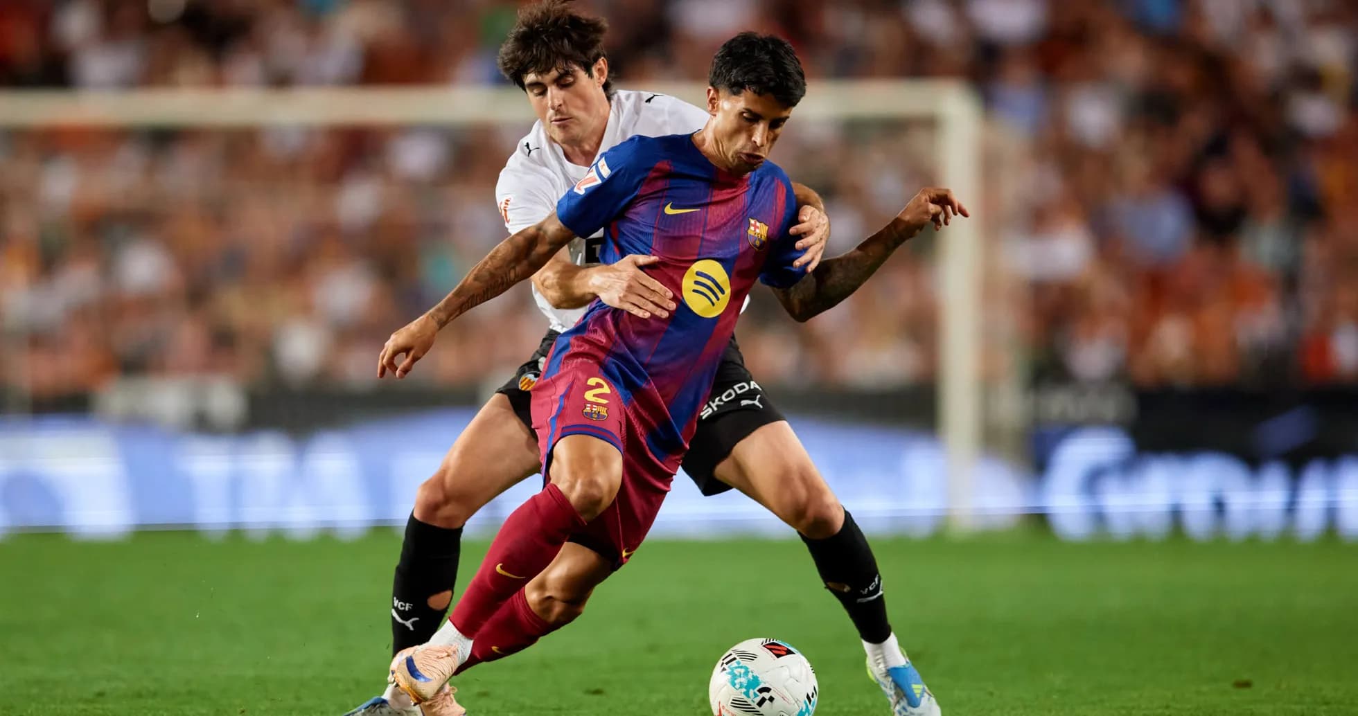 Jugador del Barcelona siendo tackleado por oponente