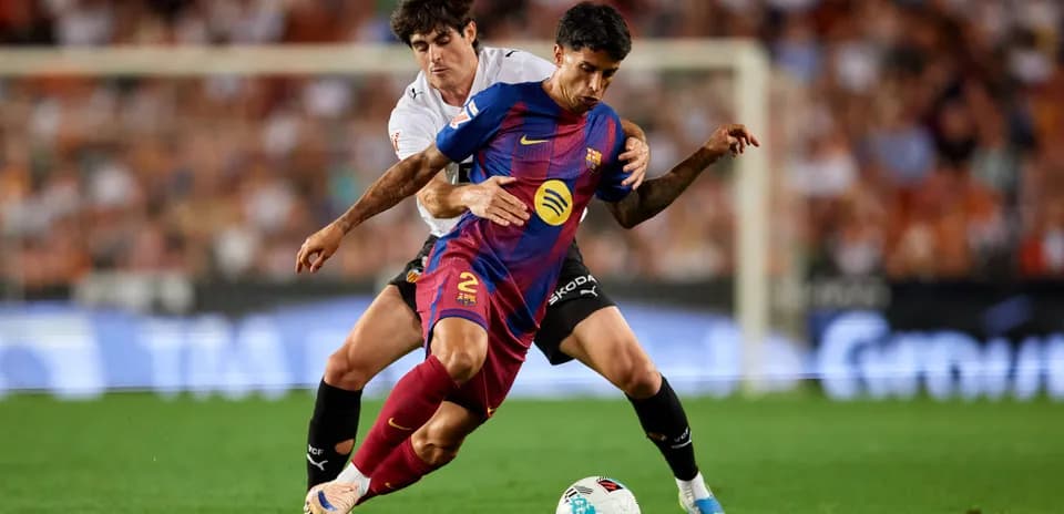 Jugador del Barcelona siendo tackleado por oponente