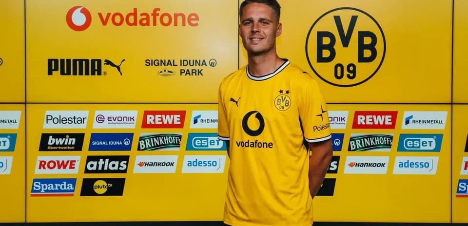 Jugador posando en conferencia con camiseta del Borussia Dortmund