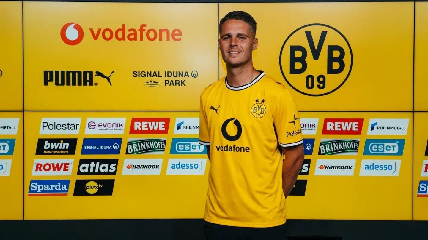 Jugador posando en conferencia con camiseta del Borussia Dortmund