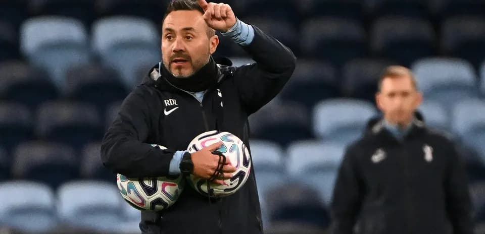 Entrenador dando instrucciones con balones en brazos