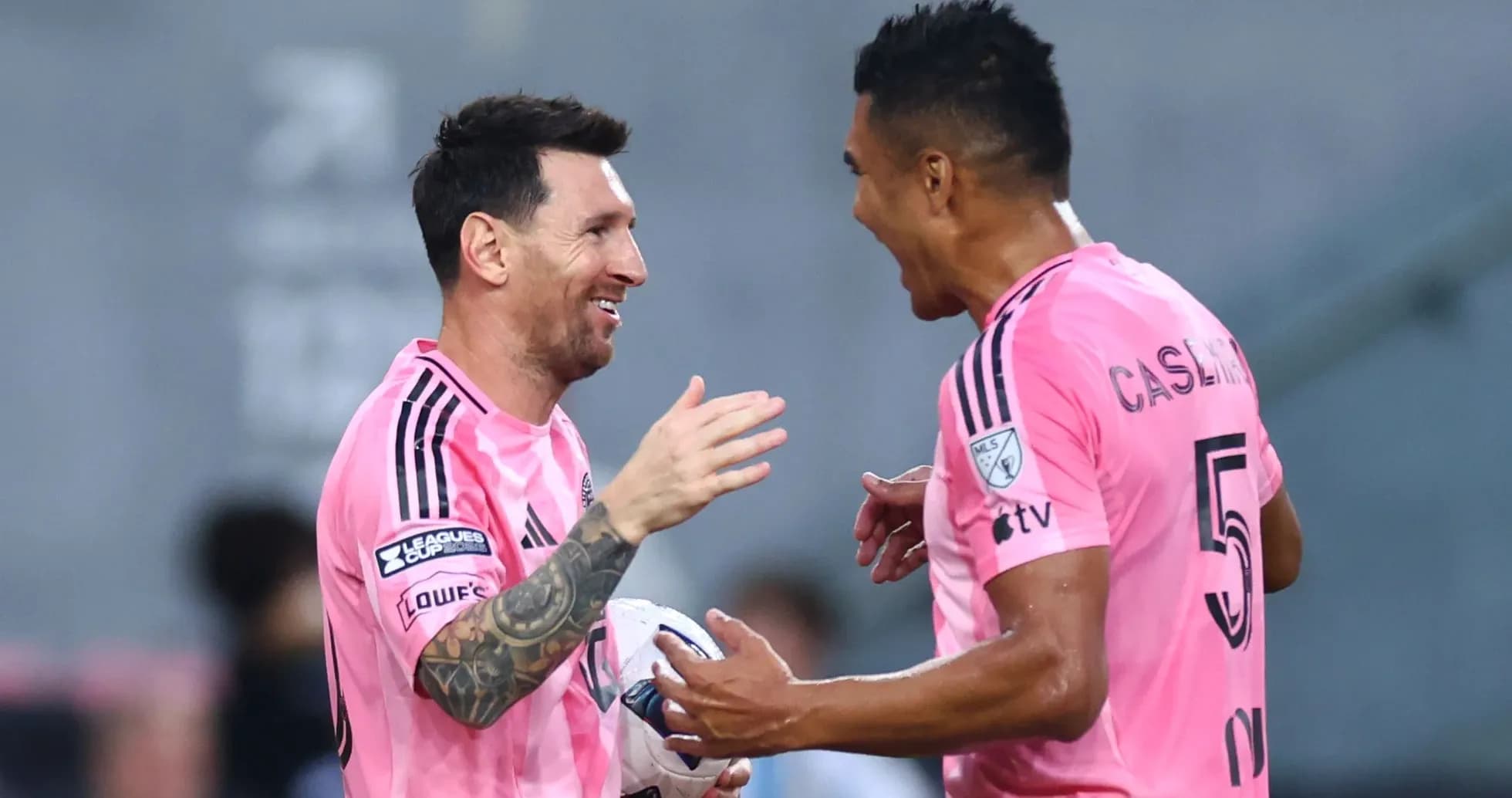 Jugadores celebrando en el campo con camisetas rosas