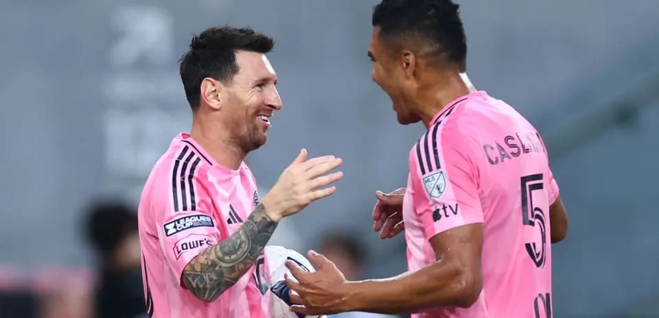 Jugadores celebrando en el campo con camisetas rosas