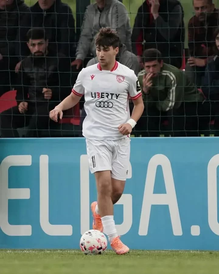 Jugador con balón en campo durante partido de fútbol