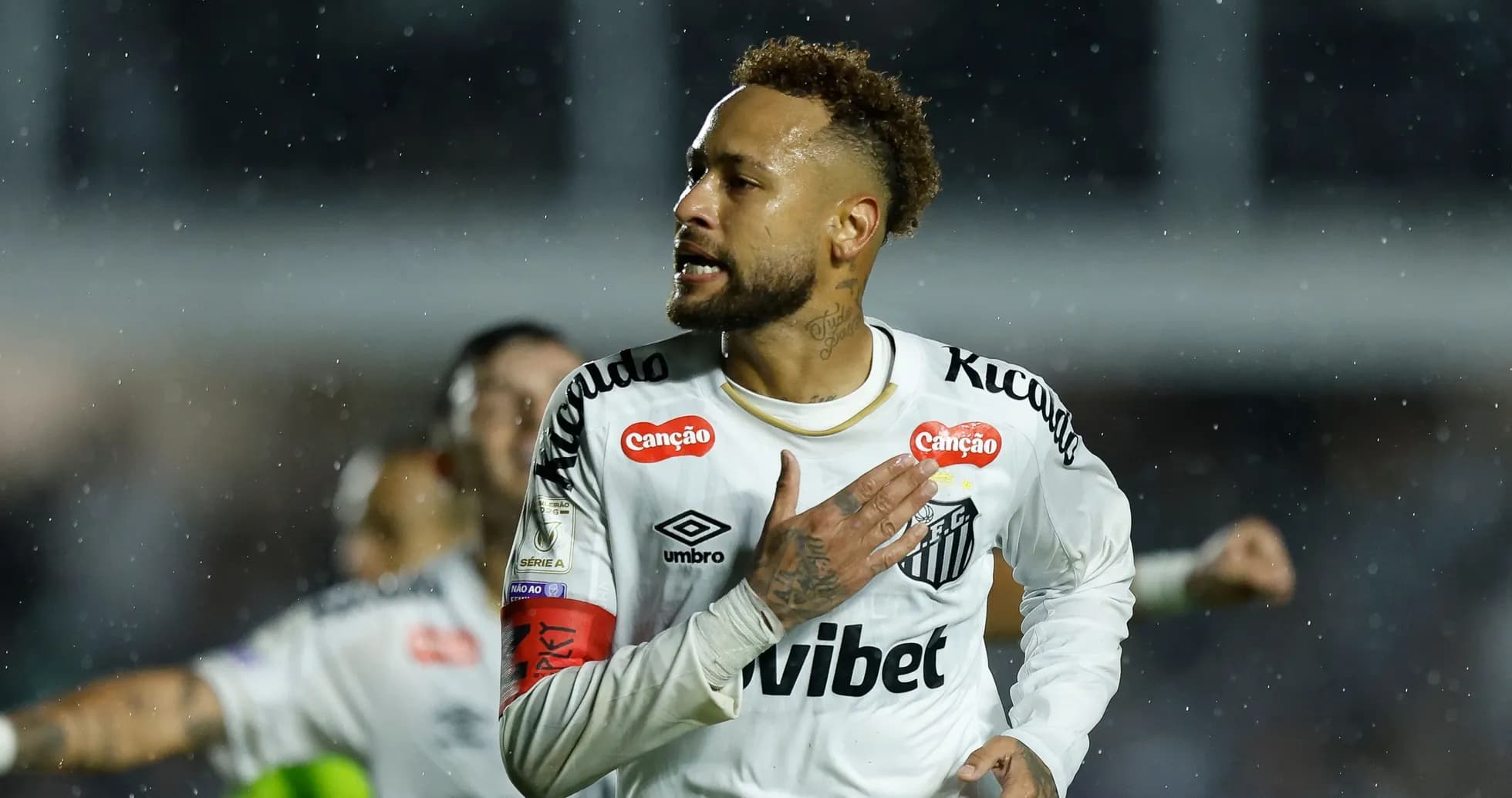Jugador celebrando un gol bajo la lluvia