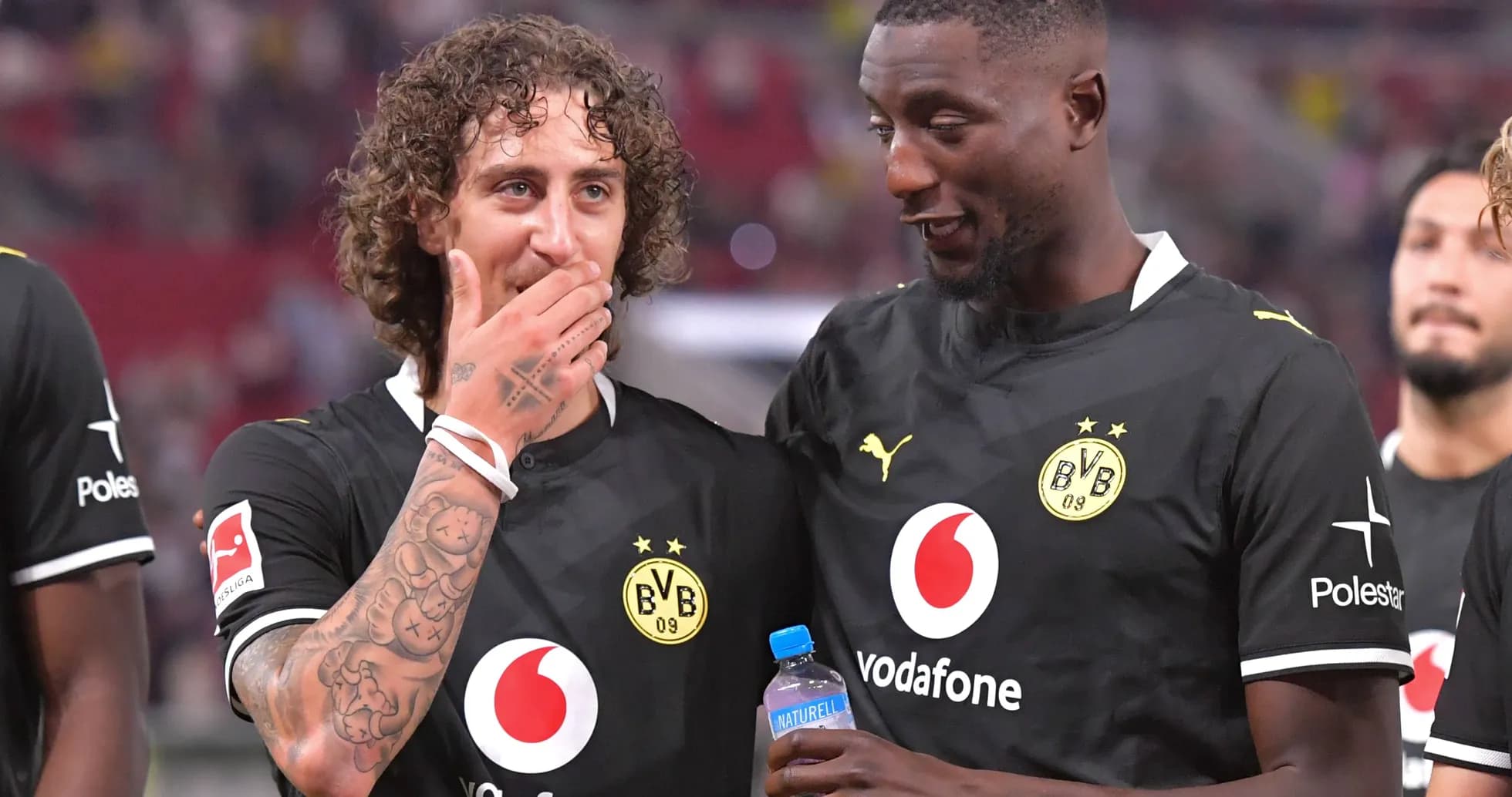 Jugadores de Borussia Dortmund conversando en el campo