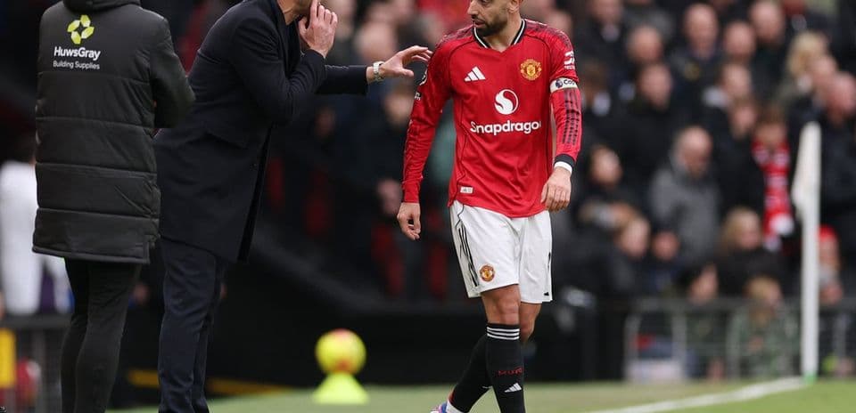 Entrenador dando instrucciones a jugador de Manchester United