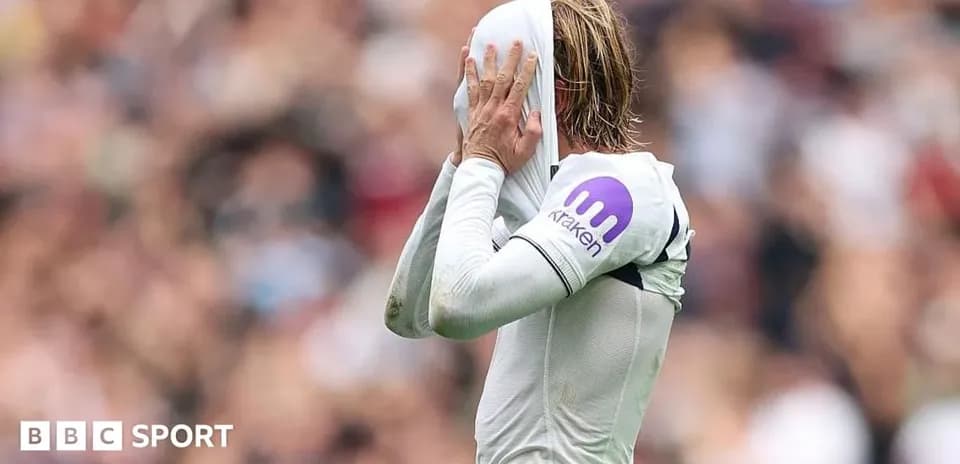 Jugador cubriendo su rostro con camiseta durante partido