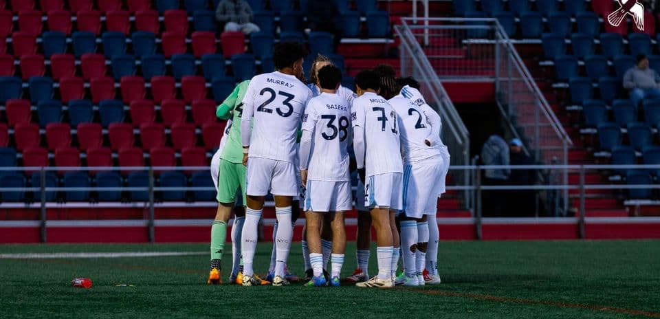 Jugadores de New York City II en huddle
