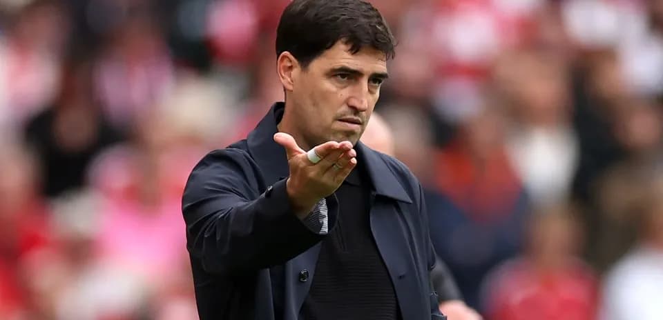 Entrenador gesticulando durante un partido de fútbol