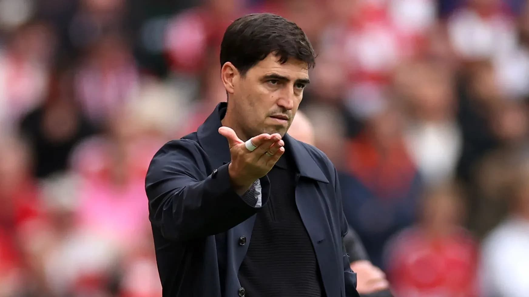 Entrenador gesticulando durante un partido de fútbol