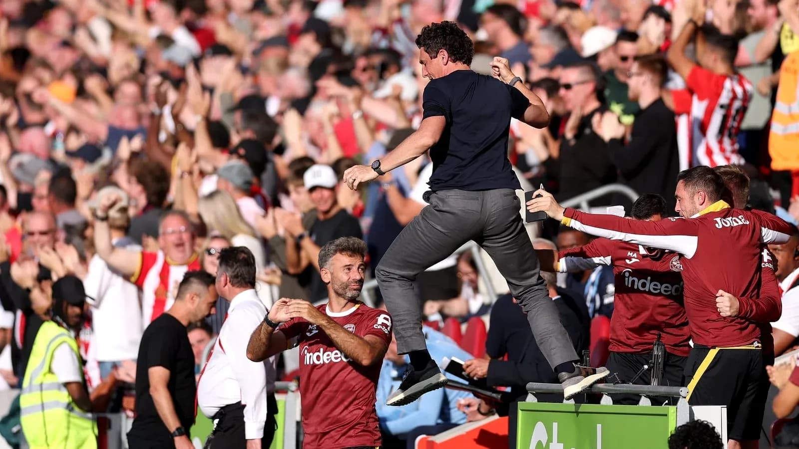 Entrenador celebrando con aficionados en el estadio