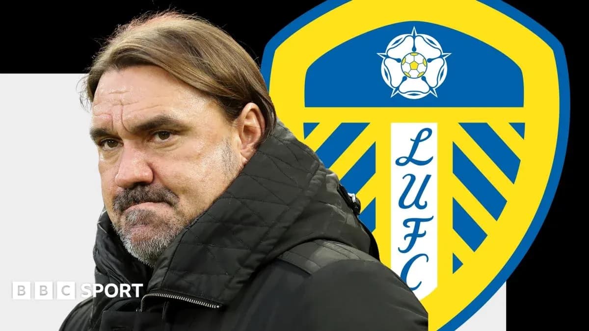 Entrenador de pie frente al escudo de Leeds United