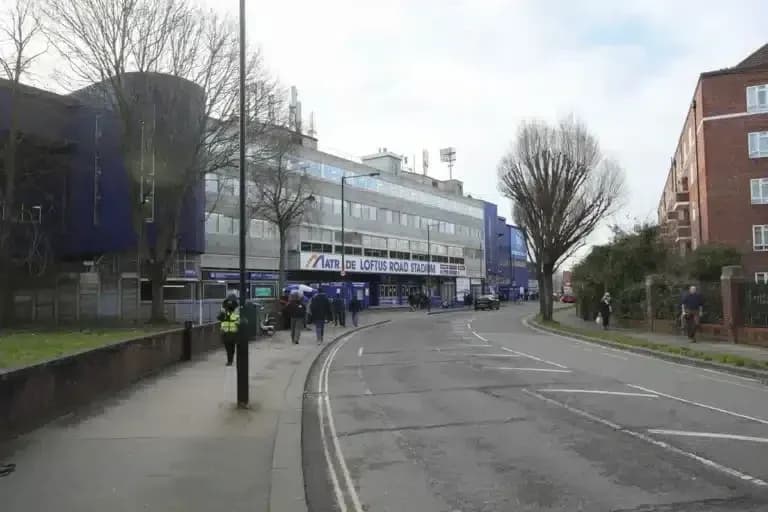 Fachada del estadio Loftus Road con aficionados