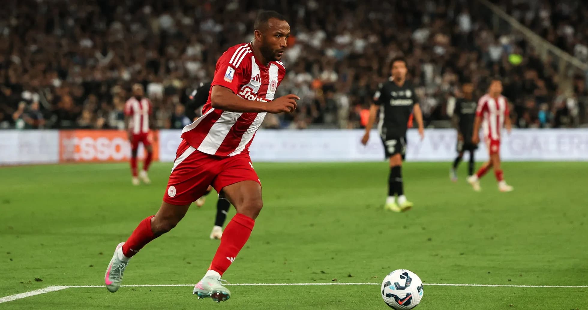 Jugador de Olympiakos corriendo tras el balón en el campo