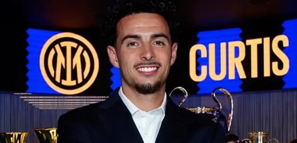 Jugador sonriente junto a trofeos y logo del club