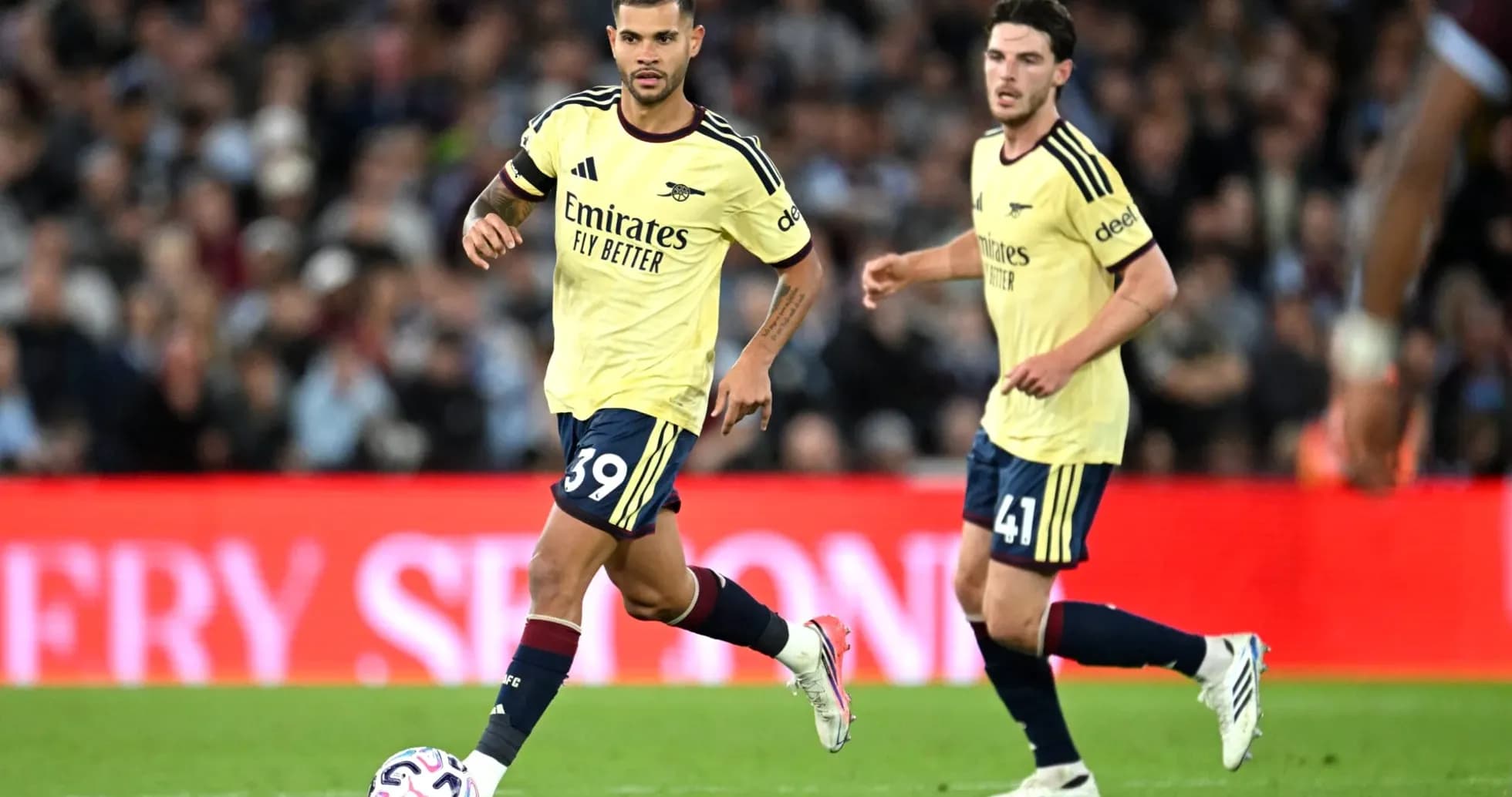 Jugadores de Arsenal corriendo con el balón en el campo