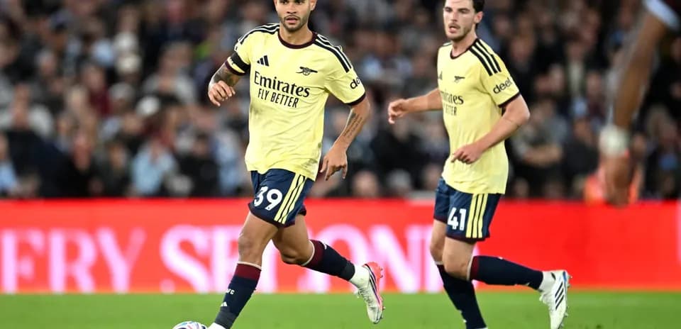 Jugadores de Arsenal corriendo con el balón en el campo