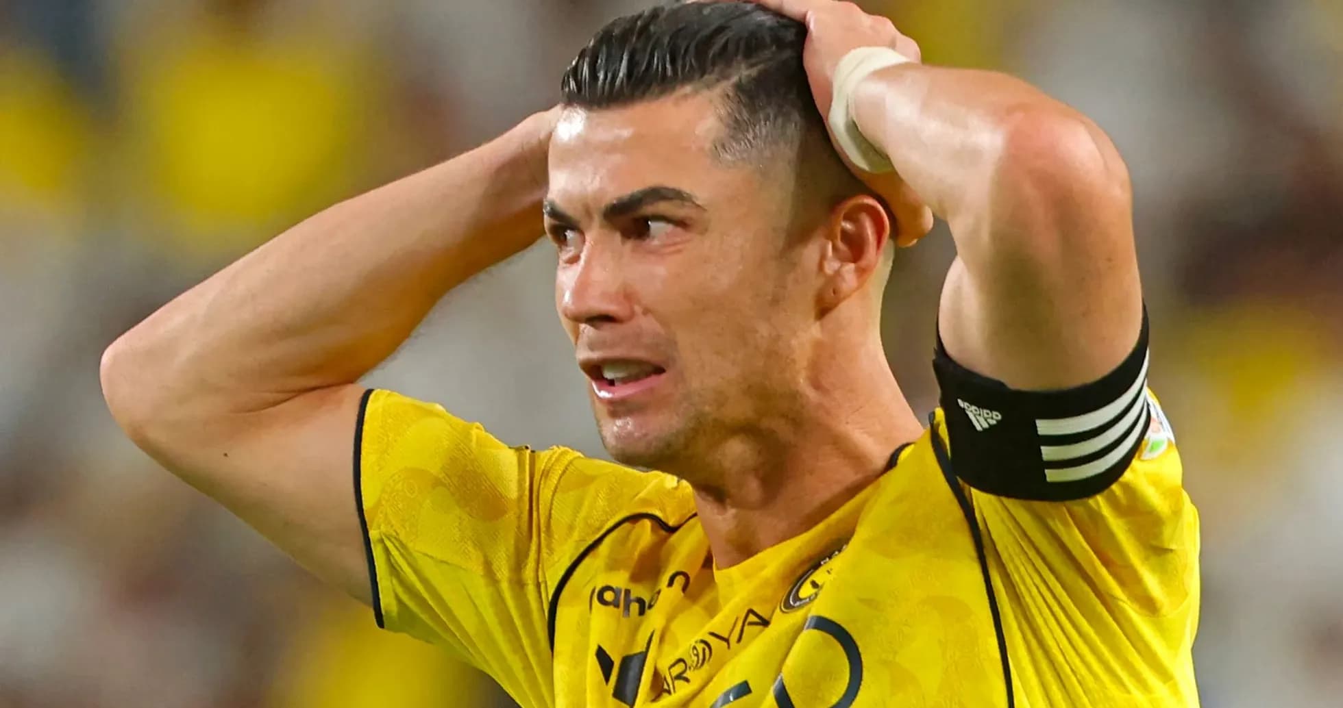 Jugador con camiseta amarilla sujetándose la cabeza