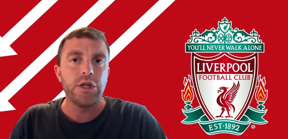 Hombre hablando frente al escudo de Liverpool FC
