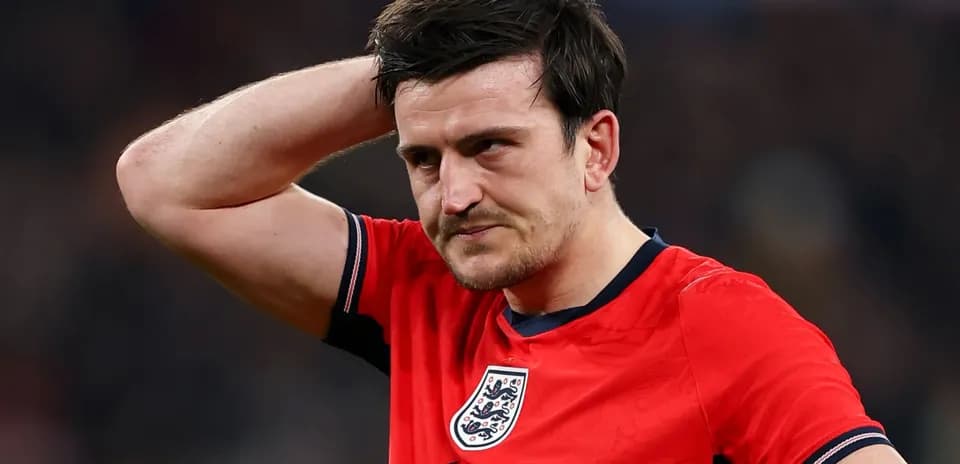 Jugador de Inglaterra con camiseta roja, pensativo en el campo