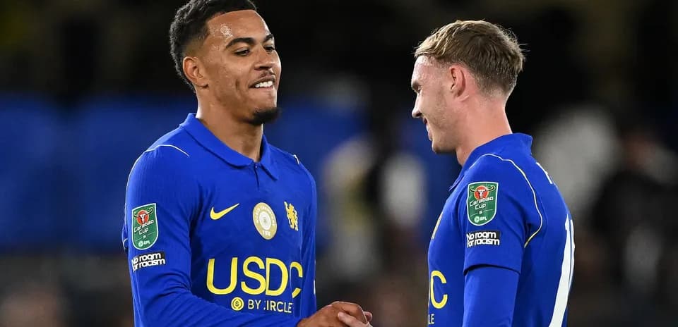 Dos jugadores de Chelsea chocando las manos en el campo