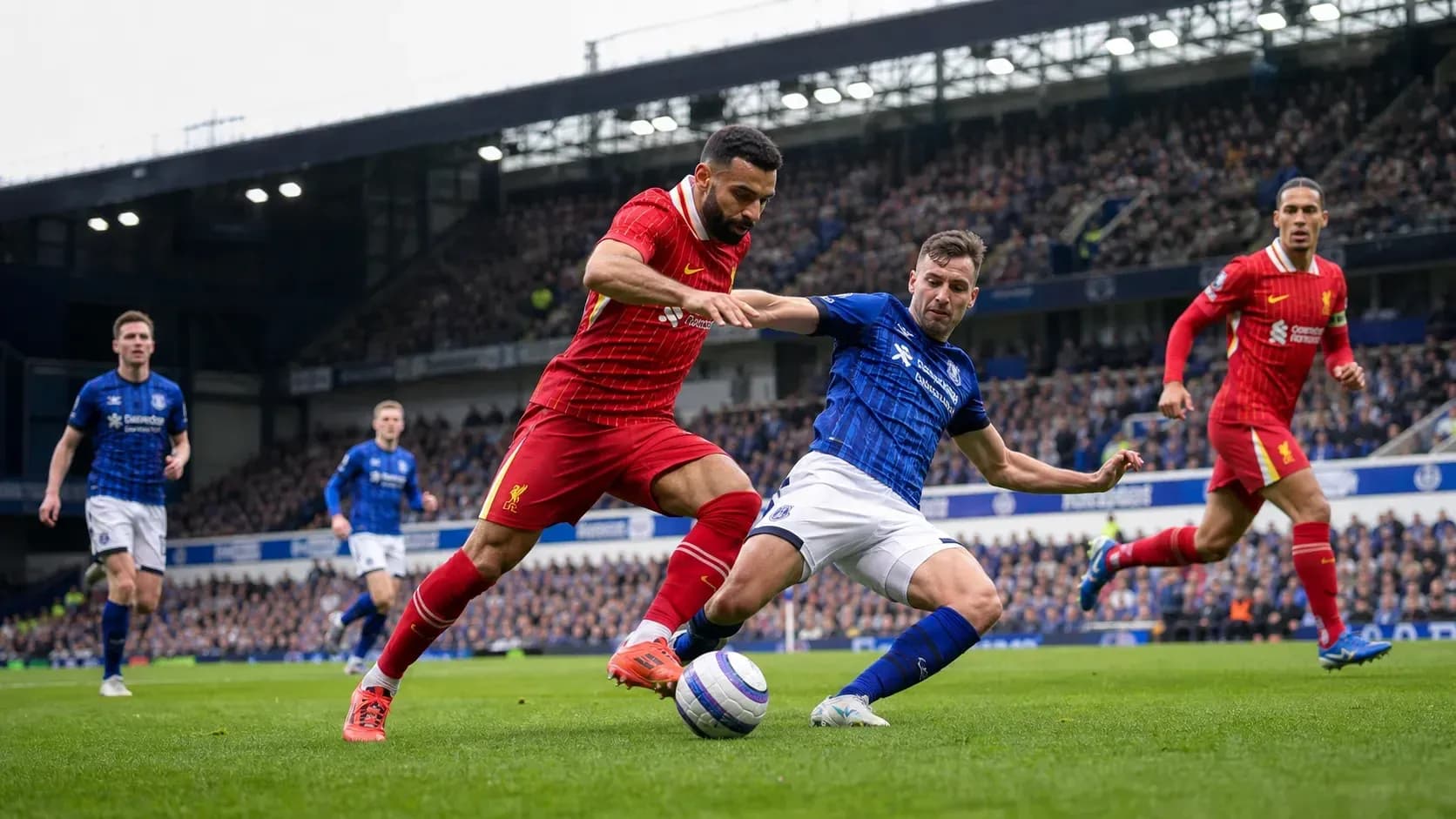 Jugadores de Liverpool y Everton luchando por el balón