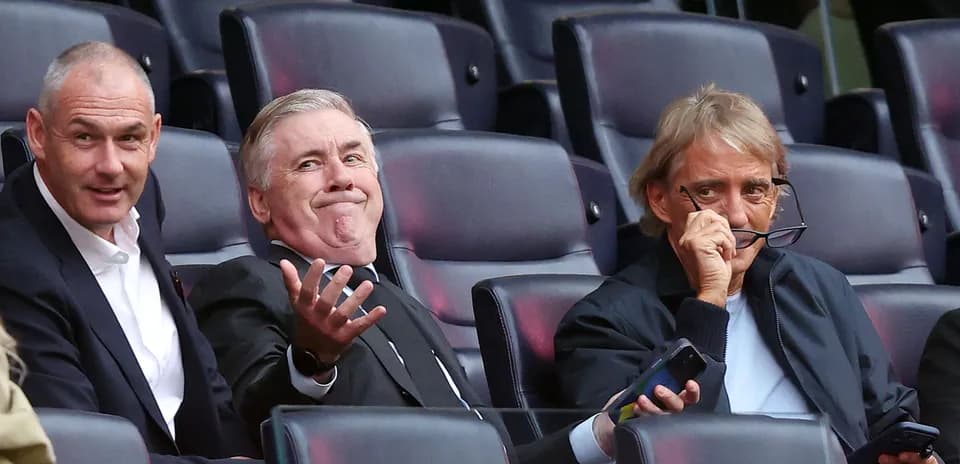 Tres hombres sentados en un estadio durante evento